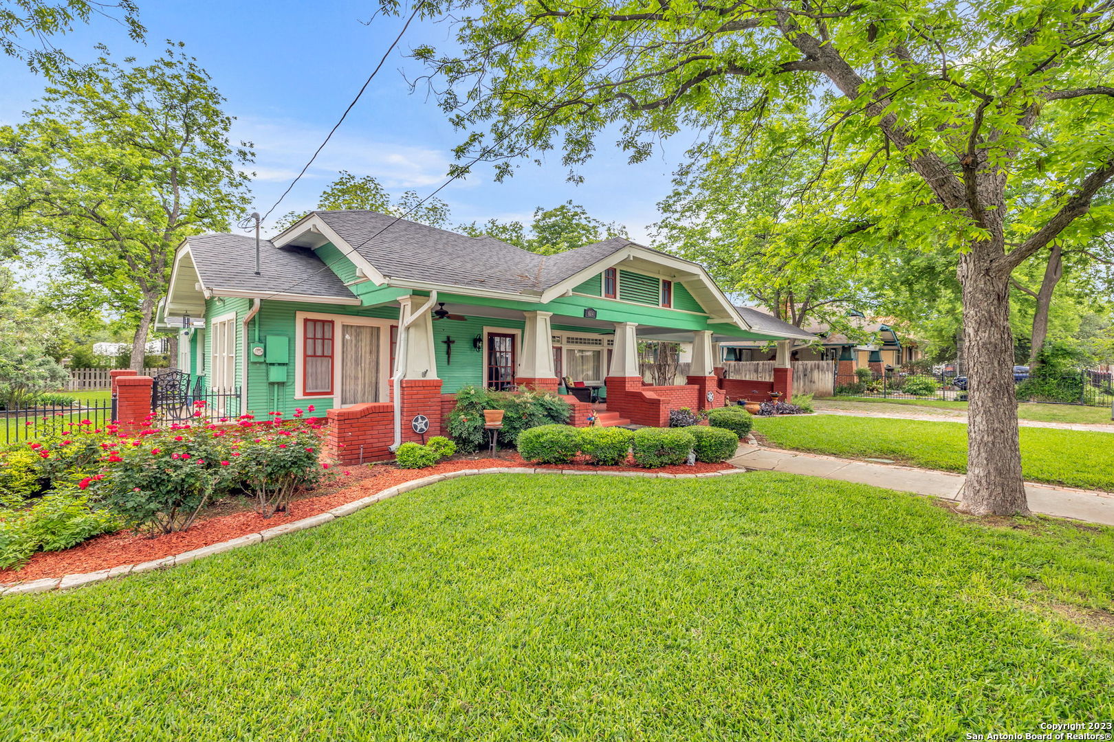 This stunning single-story Craftsman style home is located in the heart of San Antonio, just steps away from all of the city's top attractions, including the Pearl Brewery and the Museum Reach section of the Riverwalk. This home in the Tobin Hill Historic District boasts plenty of charm and character, from its original hardwood floors and wood trim to its custom built-ins and unique architectural features.  As you enter the home from the incredible front patio and step inside, you'll be greeted by a spacious living room with a cozy fireplace and plenty of natural light streaming in from the large windows. The adjacent large dining room leads into another large living space and large updated kitchen.  The home is currently set up with two comfortable bedrooms, but has two additional rooms currently used as an office and living space which could easily be used as additional bedrooms.  Outside, this home sits on a huge lot with a detached two-car garage that has previously been used as a separate apartment. The expansive backyard offers plenty of space for entertaining and gardening, with mature trees providing shade and privacy; the landscaping at this home is immaculate!  This is truly a rare find - a historic home with all the charm and modern amenities you need and a location that can't be beat.